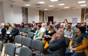 Uczestnicy konferencji siedzą i słuchaja wygłaszanego referatu.