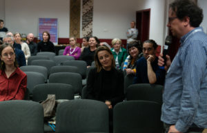 Uczestnicy konferencji podczas dyskusji. Mężczyzna mówi do mikrofonu.